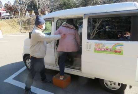 送迎車へ乗り込む利用者を支援する様子